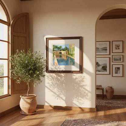 framed print of “Swimming Pool, Southern France” hanging in a sunlit Mediterranean-style interior with warm stucco walls, olive plants, soft coastal light, and a premium hardwood frame.